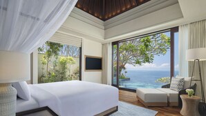 Un dormitorio con una cama grande, televisión y vistas al océano.