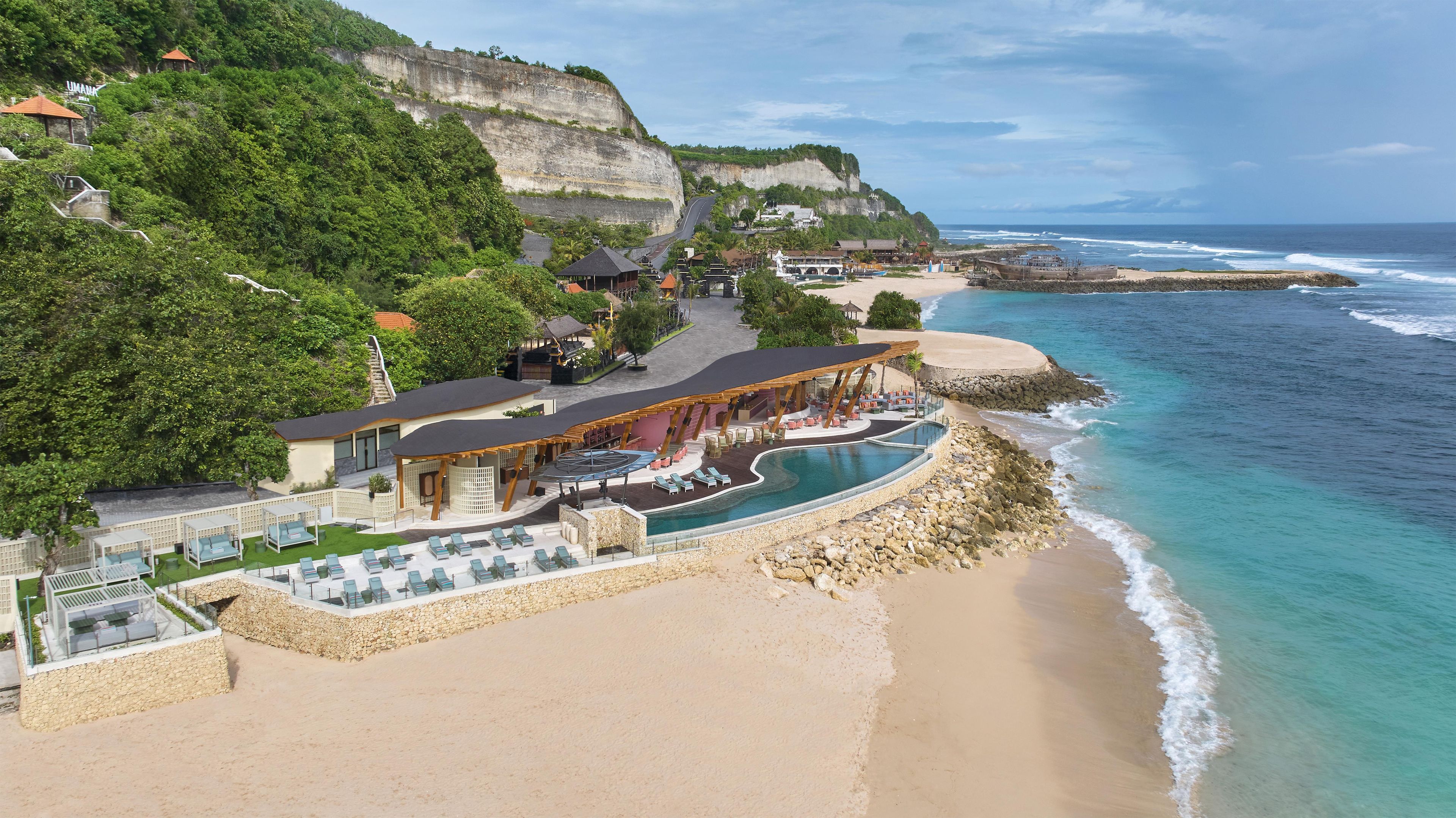 A coastal resort with a swimming pool, beach, and cliffside views.