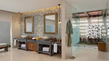 Une salle de bain moderne avec un meuble-lavabo double, deux grands miroirs et une douche à parois de verre.