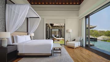 A modern hotel room with a large bed, bedside tables, a bench, and a view of a pool.