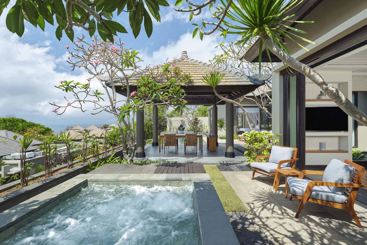 A spa area with a hot tub, wooden lounge chairs, and a gazebo.