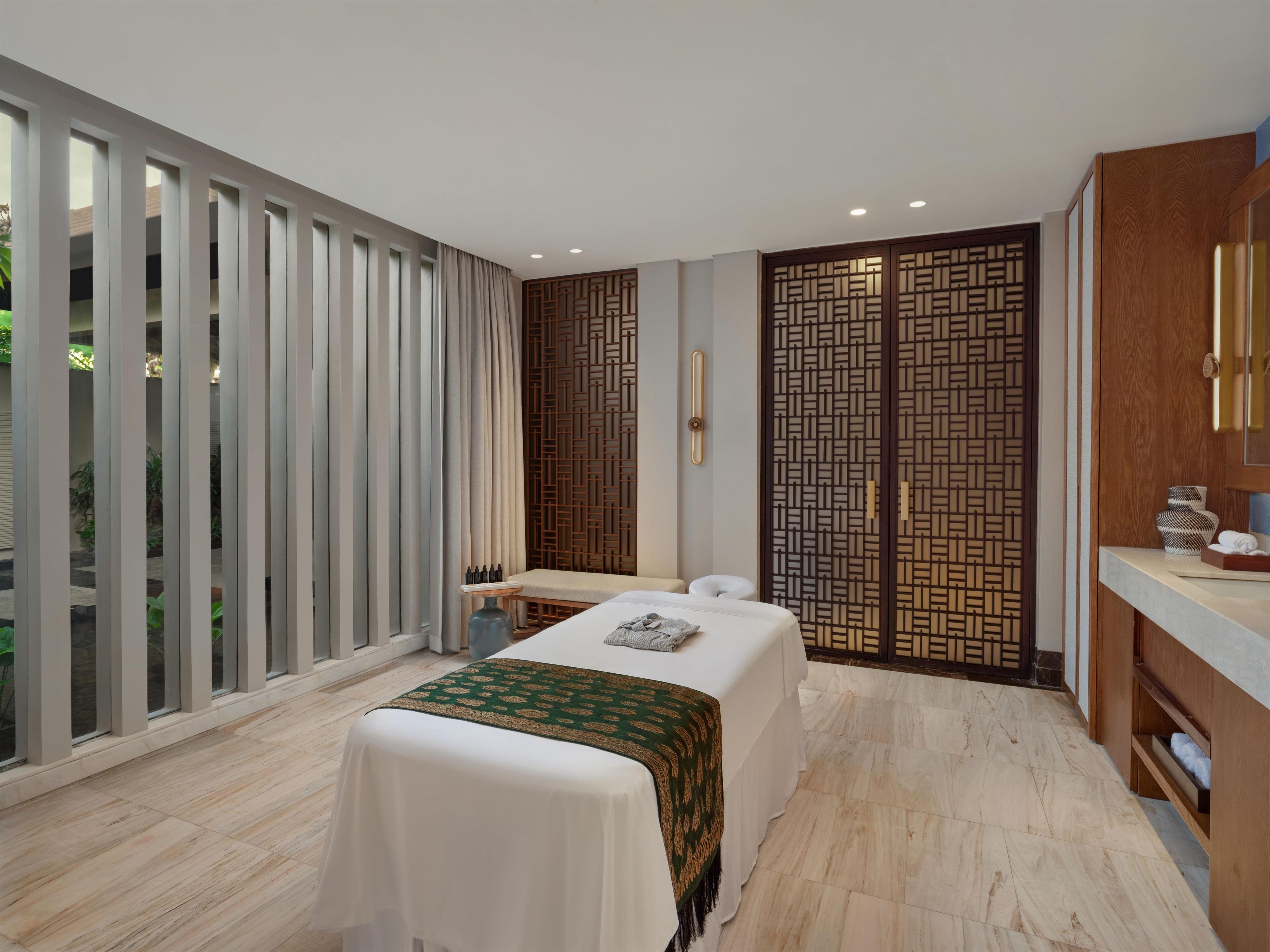 A modern room with a bed, a small table, and a wooden partition.