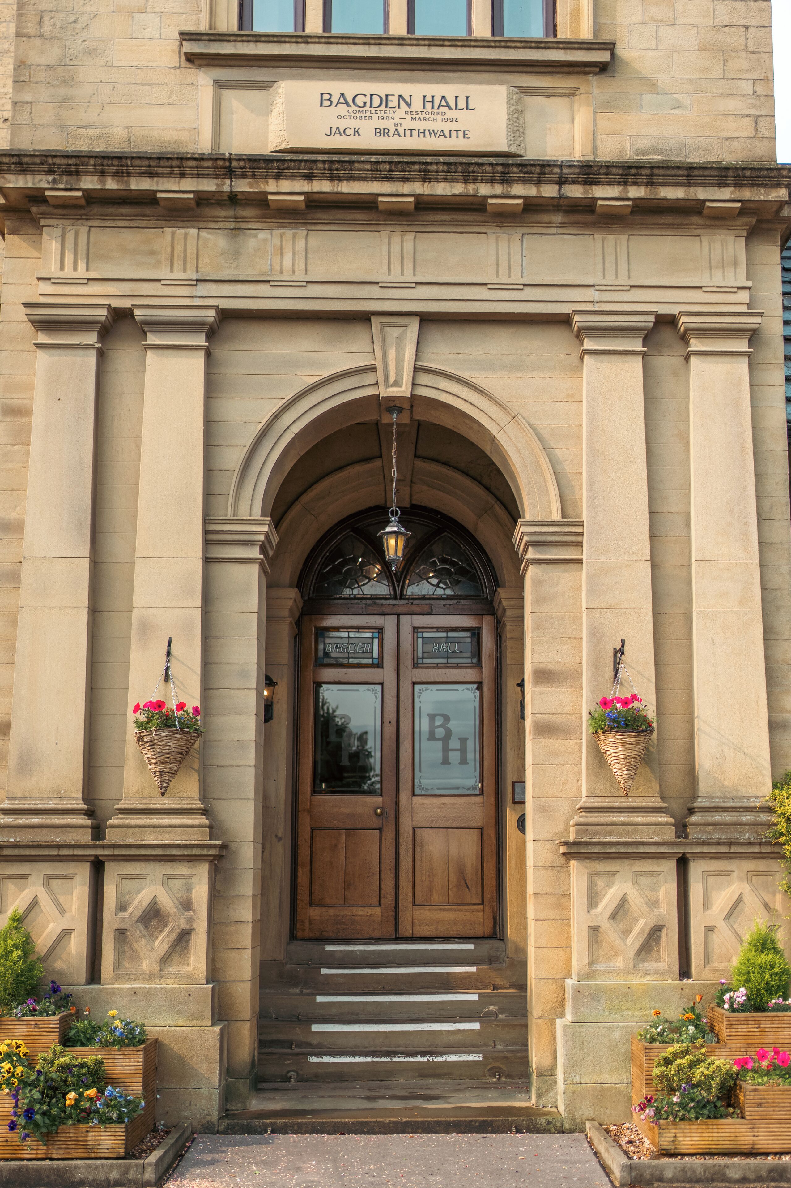 A building entrance with a sign reading 'BAGDEN HALL' and a date 'OCTOBER 1989 - RESTORED MARCH 1992'.