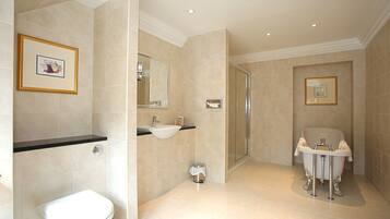 A bathroom with a toilet, sink, and shower area.