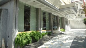A modern building with large windows, a covered entrance, and a tiled walkway. - Regency Hotel Malabar Hill (Mumbai)
