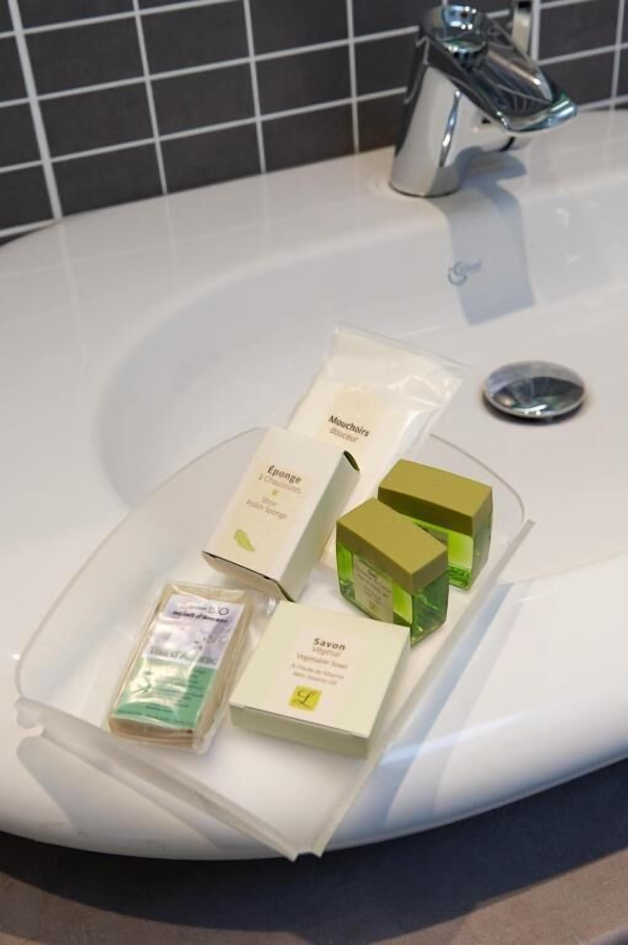 A bathroom sink with toiletries including a soap bar, a toothbrush, and a tube of toothpaste.