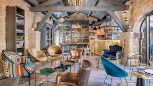 A spacious interior with a bar area, leather chairs, and a variety of seating options. - Le Mas du Terme (Barjac)