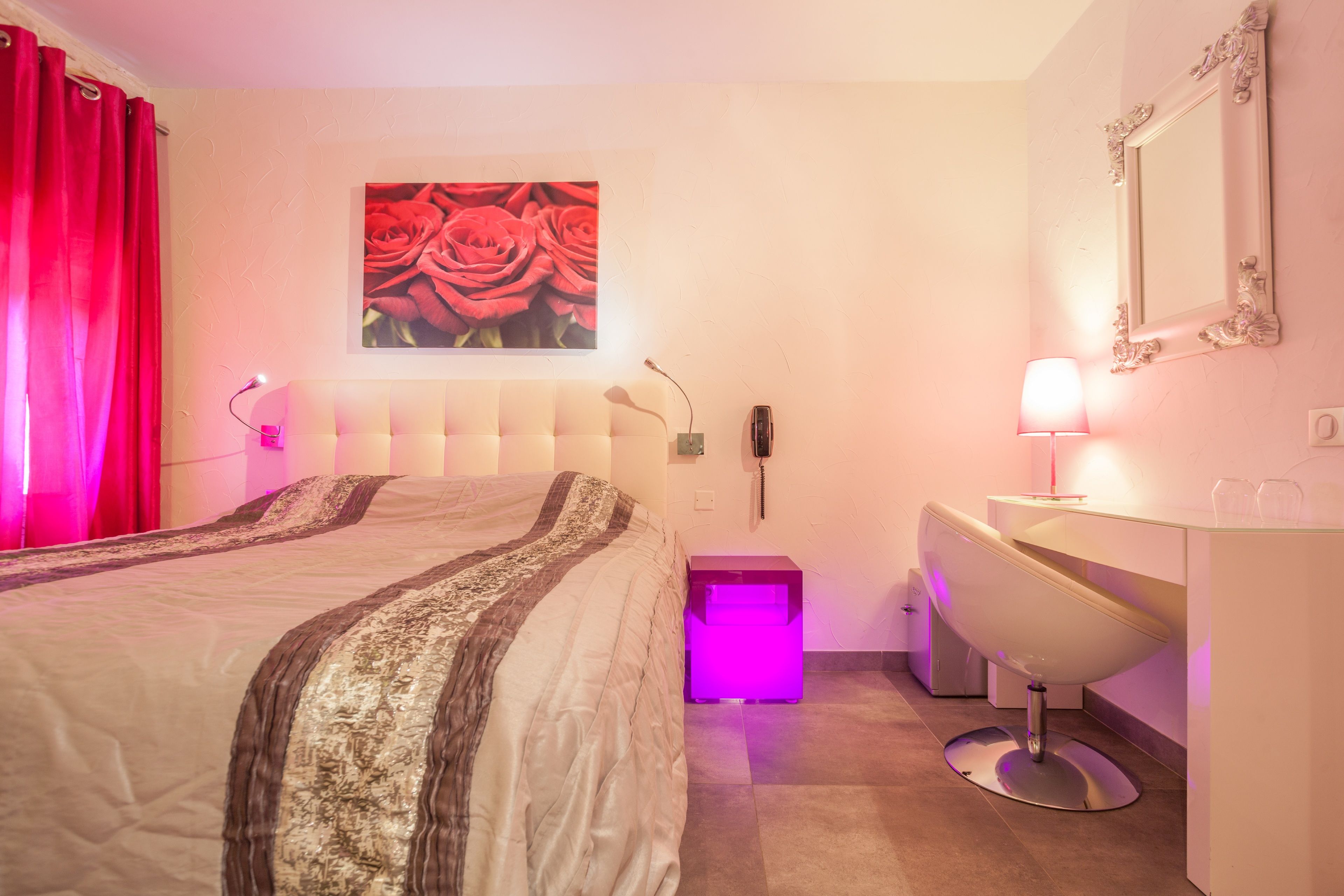 Quarto com cama, mesa de cabeceira e espelho.