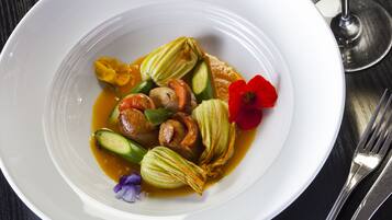 A white plate with a dish containing vegetables and flowers.
