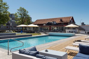 Una piscina al aire libre, sillones reclinables de piscina