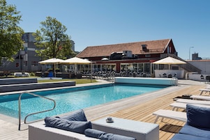 Una piscina al aire libre, sillones reclinables de piscina