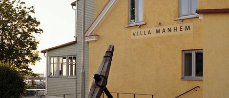 Un edificio con un letrero que dice 'VILLA MANHEM' y un farol en primer plano.