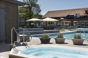 Una piscina al aire libre, sillones reclinables de piscina
