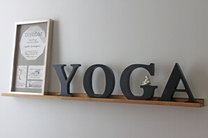 Ett inramat diplom står på en hylla, och ordet ”YOGA” är skrivet med stora bokstäver.