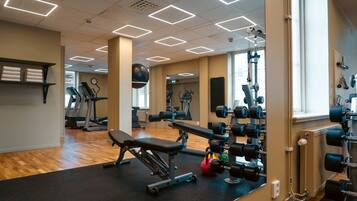 A gym with exercise equipment, a treadmill, and a mirror.