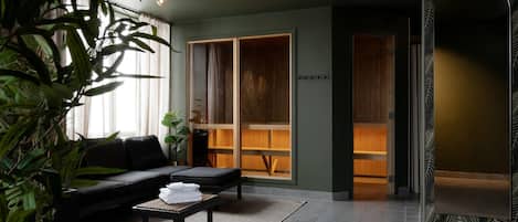 A modern living room with a sofa, a coffee table, and a large window with curtains.