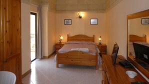 Une chambre à coucher avec un lit en bois, des tables de chevet avec des lampes, un miroir et un bureau avec un ordinateur.