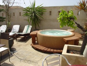 Relax in the hot tub surrounded by comfortable loungers and chairs on this tranquil patio.