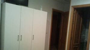 A room with a bed, a wardrobe, and a door leading to another room. - Hostal Emilio (Madrid)