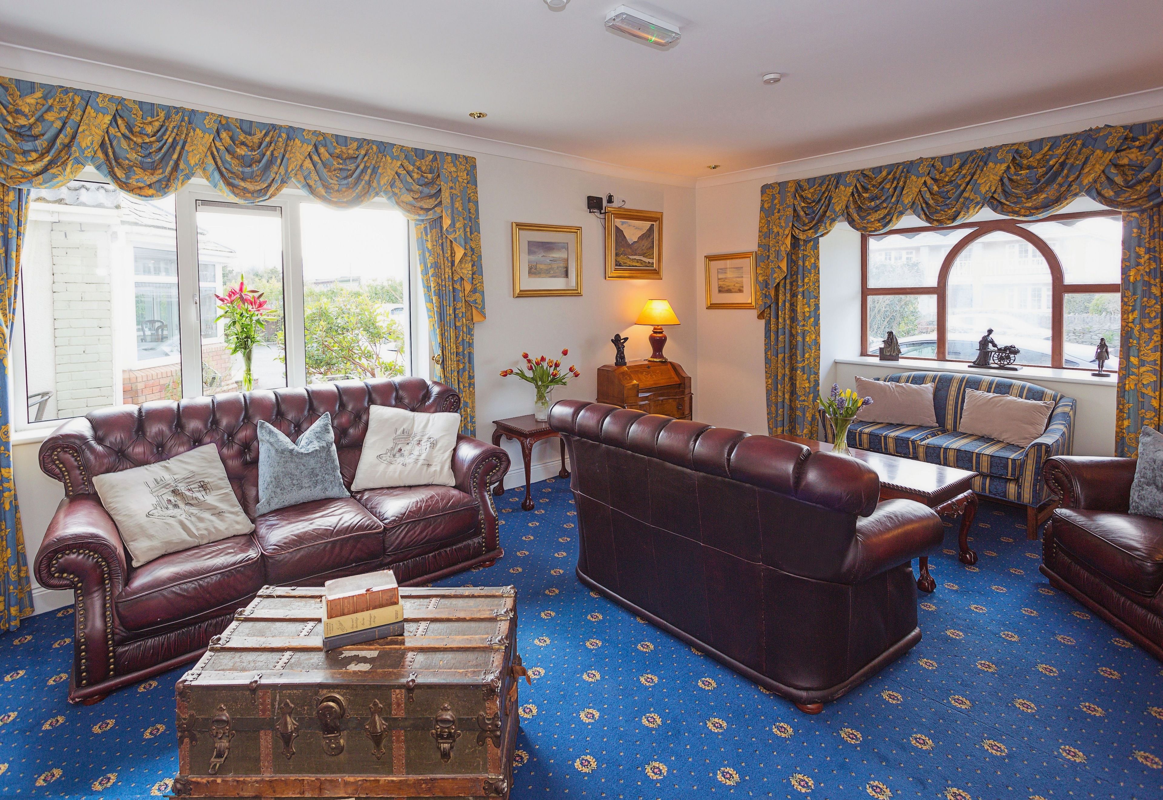A traditional room with a leather sofa, a wooden coffee table, and a vintage trunk.