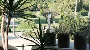 A view of a mosque with tall minarets, palm trees, and a statue in a landscaped garden. - Hotel Bosnali - Special Class (Adana)
