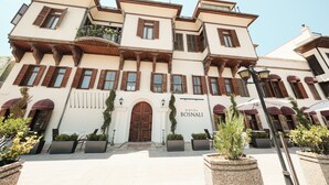 A multi-story hotel with a classic architectural style, featuring a central entrance with a large wooden door, multiple balconies, and a sign that reads "HOTEL BOSNALI". - Hotel Bosnali - Special Class (Adana)