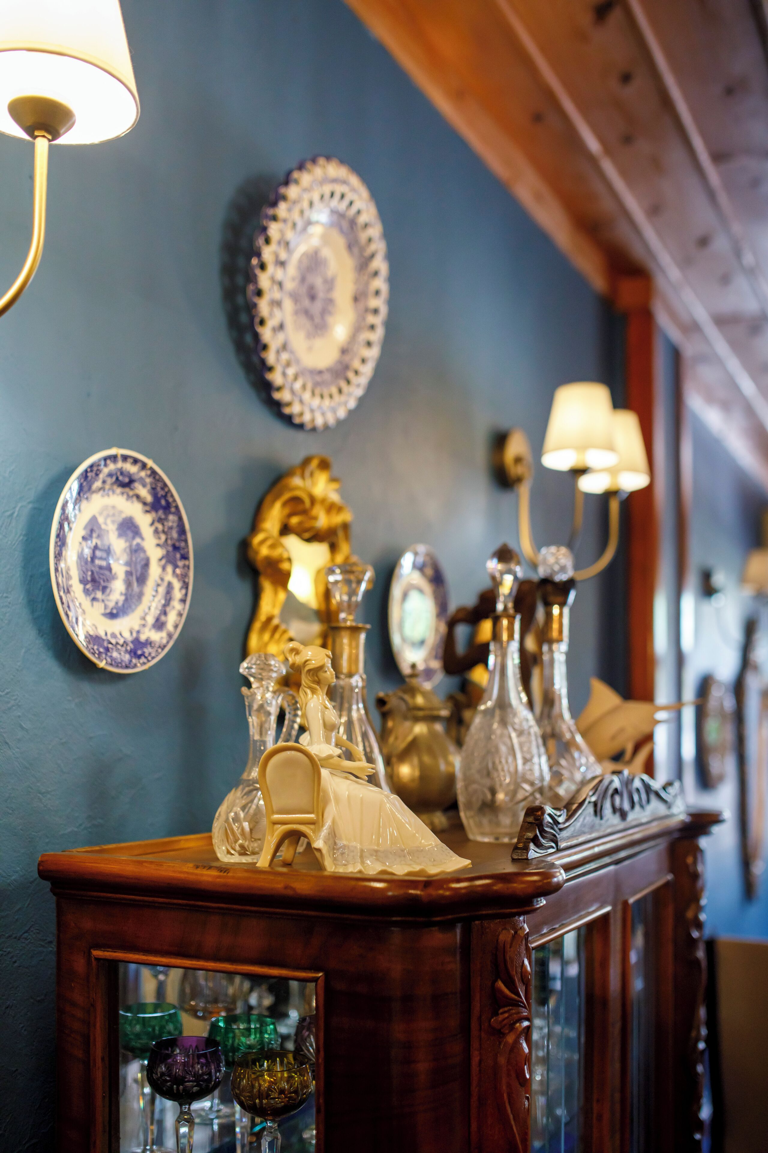 A wooden cabinet with glassware and a mirror.