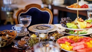 A dining table set with various dishes, glasses, and a decorative centerpiece. - Hotel Bosnali - Special Class (Adana)