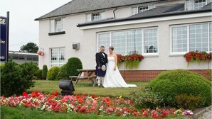 A building with a white facade, large windows, and a brick chimney. - Solway Lodge Hotel (Gretna)