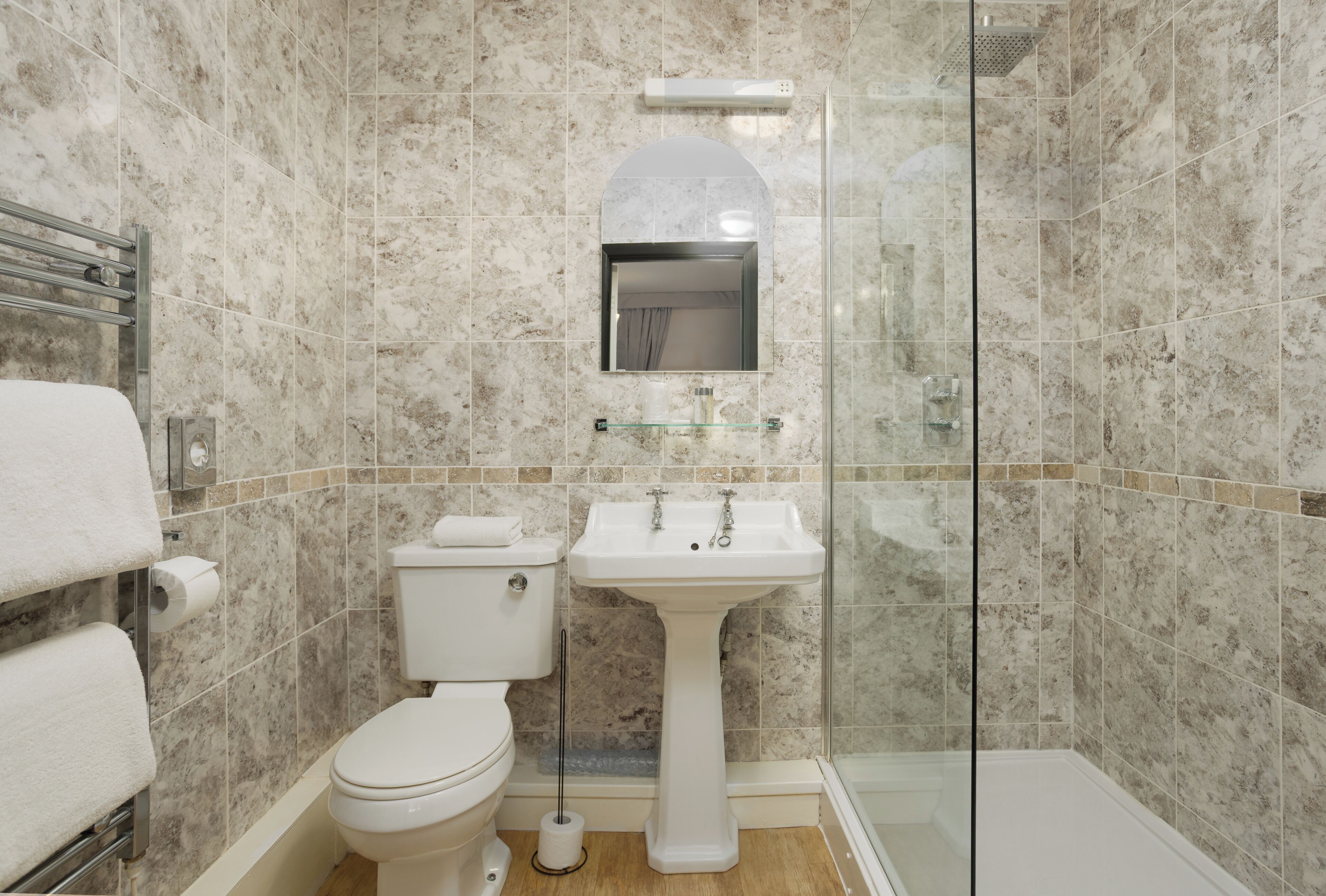 A bathroom with a toilet, sink, and shower.