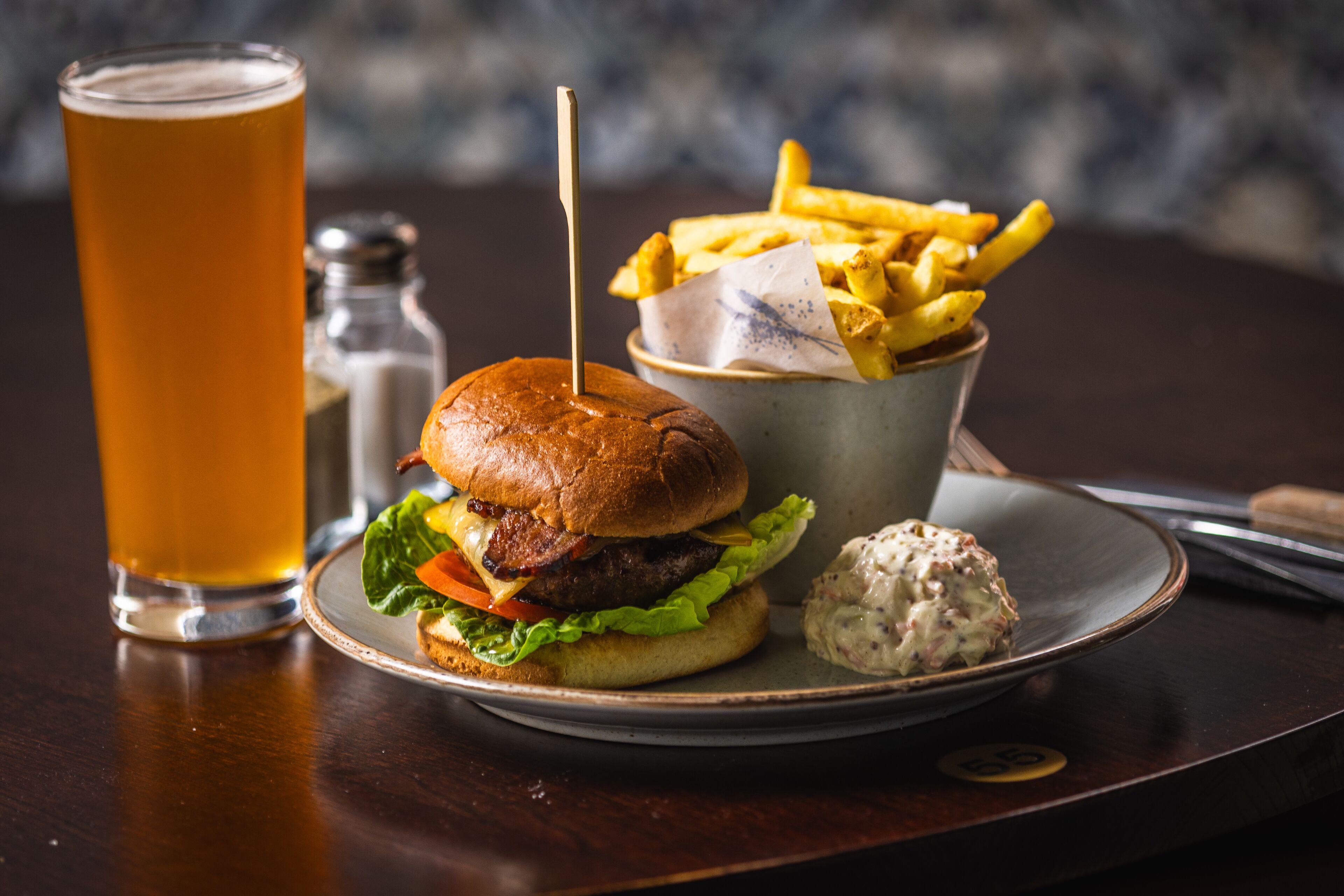 A meal consisting of a burger, fries, and a drink on a plate.