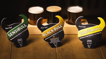 Three beer bottles with labels on a wooden surface.
