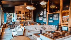 A modern interior with a bar area, seating arrangements, and artwork on the walls. - Hotel Lago Grey (Torres del Paine)