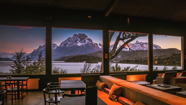 A restaurant with a view of a mountain range and a lake. - Hotel Lago Grey (Torres del Paine)