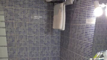 A bathroom with a bathtub, a sink, and a mirror.