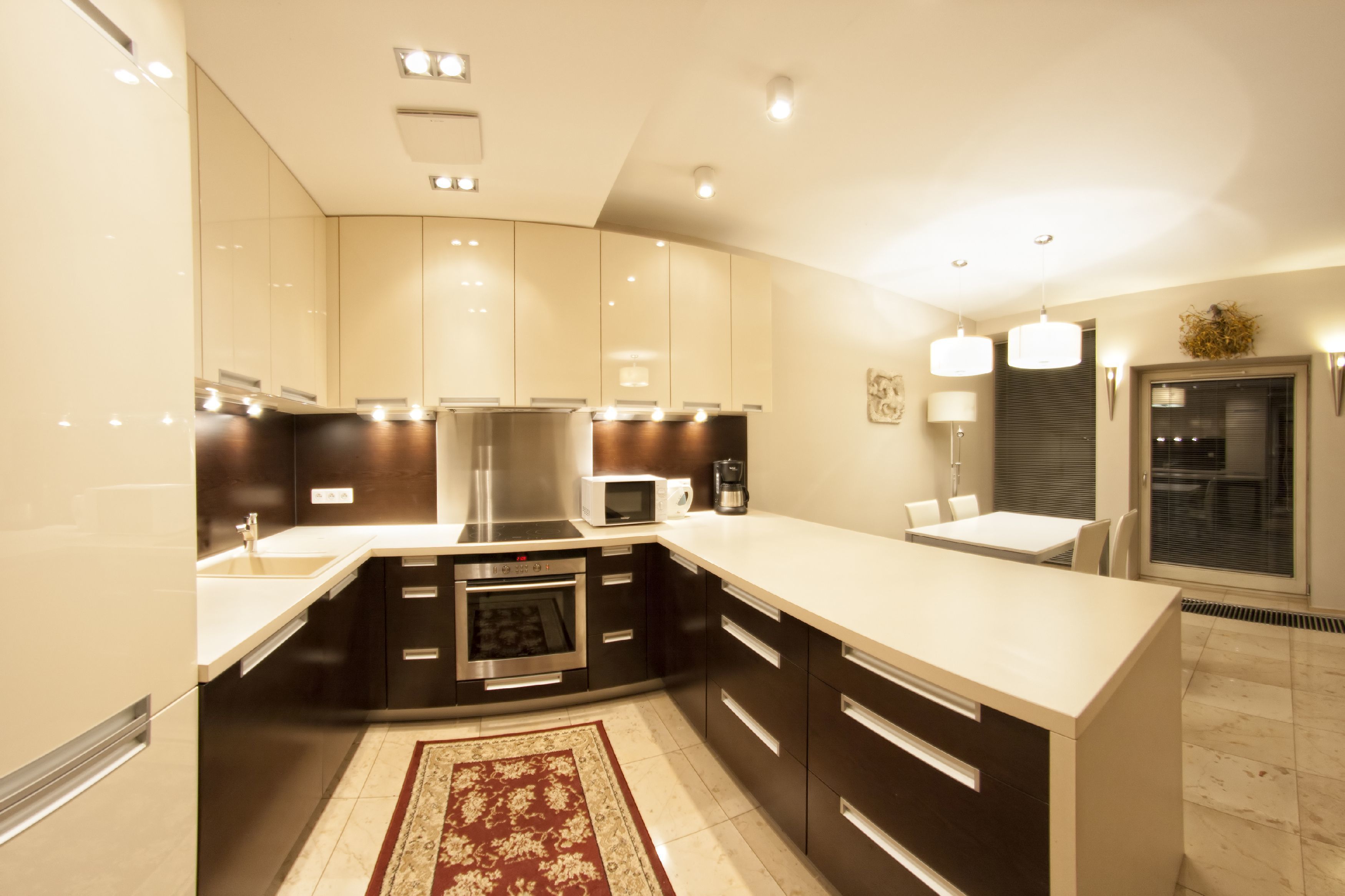 A modern kitchen with dark cabinetry, a central island, and built-in appliances.