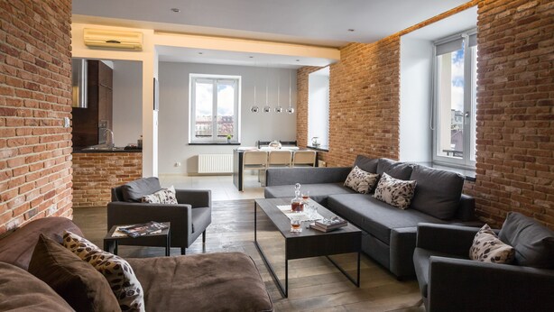 A modern living room with a sofa set, a coffee table, and a dining area with a table and chairs.