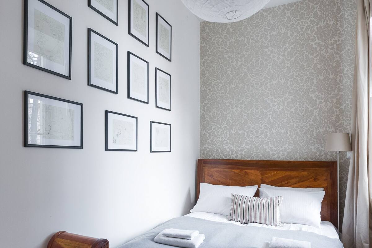 Ein ordentlich eingerichtetes Hotelzimmer mit einem großen Bett, einer Holzbank und einem gemusterten Teppich.
