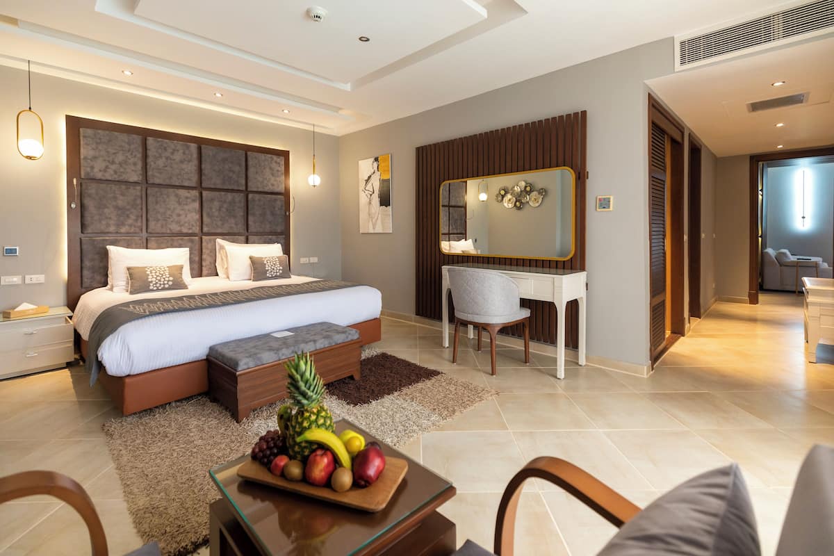 Un dormitorio moderno con una cama grande, un escritorio y un espejo.