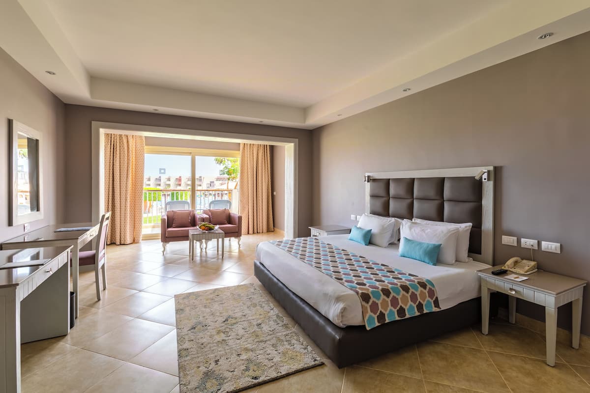 Habitación de hotel moderna con una cama grande, un escritorio, una silla y vistas al exterior.