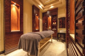 Ett spa-rum med en väggpanel av trä, en bänk, ett handfat och en spegel.