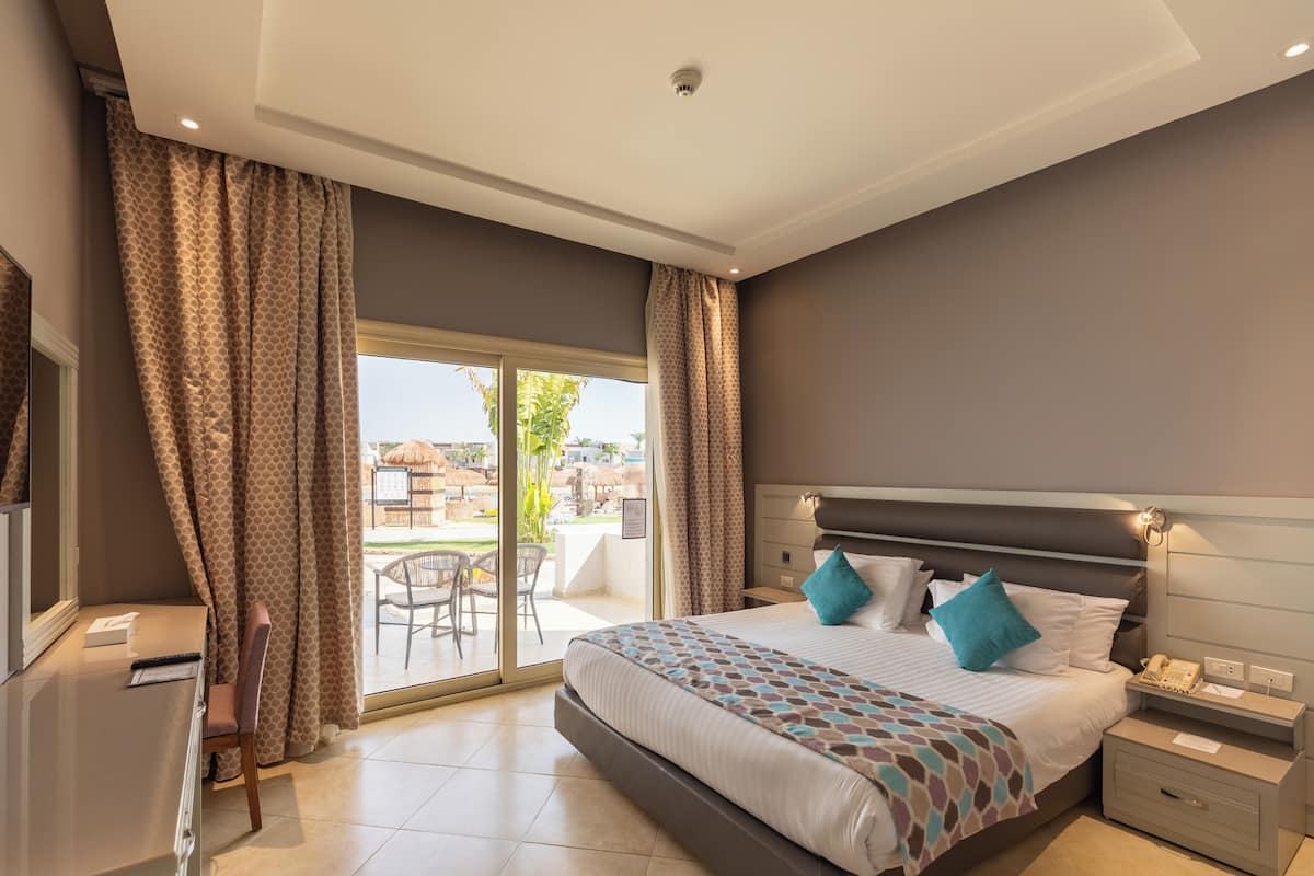 Un dormitorio con una cama grande, un escritorio y vistas al exterior.