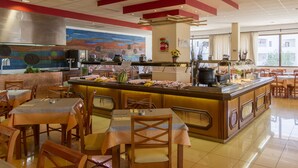 A restaurant with a central bar, multiple dining tables, and chairs.