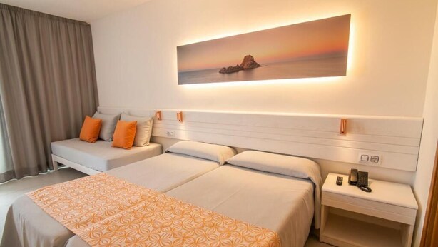 A hotel room with two beds, a sofa bed, a painting, a telephone, and a nightstand. - Hotel Caribe Ibiza (Santa Eulalia del Rio)