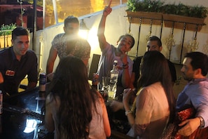 A group of people gathered around a bar area with a counter and various bottles. - Big Apple Hotel (Istanbul)