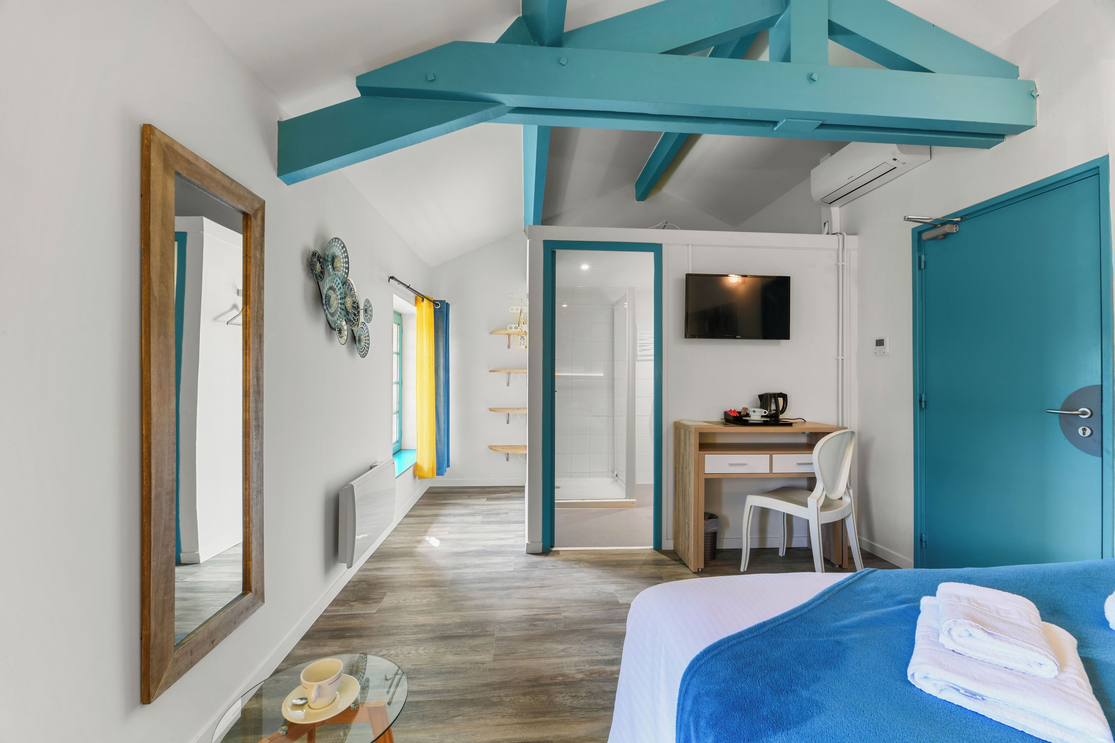 Une chambre d’hôtel moderne équipée d’un lit, d’un bureau et d’une télévision.