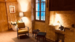 A cozy room with a wooden chair, a small table, and a decorative lamp. - L'Auberge de Larressingle (Larressingle)