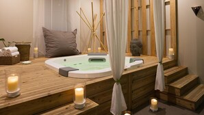 A wooden spa area with a hot tub, candles, and a decorative plant. - L'Auberge de Larressingle (Larressingle)