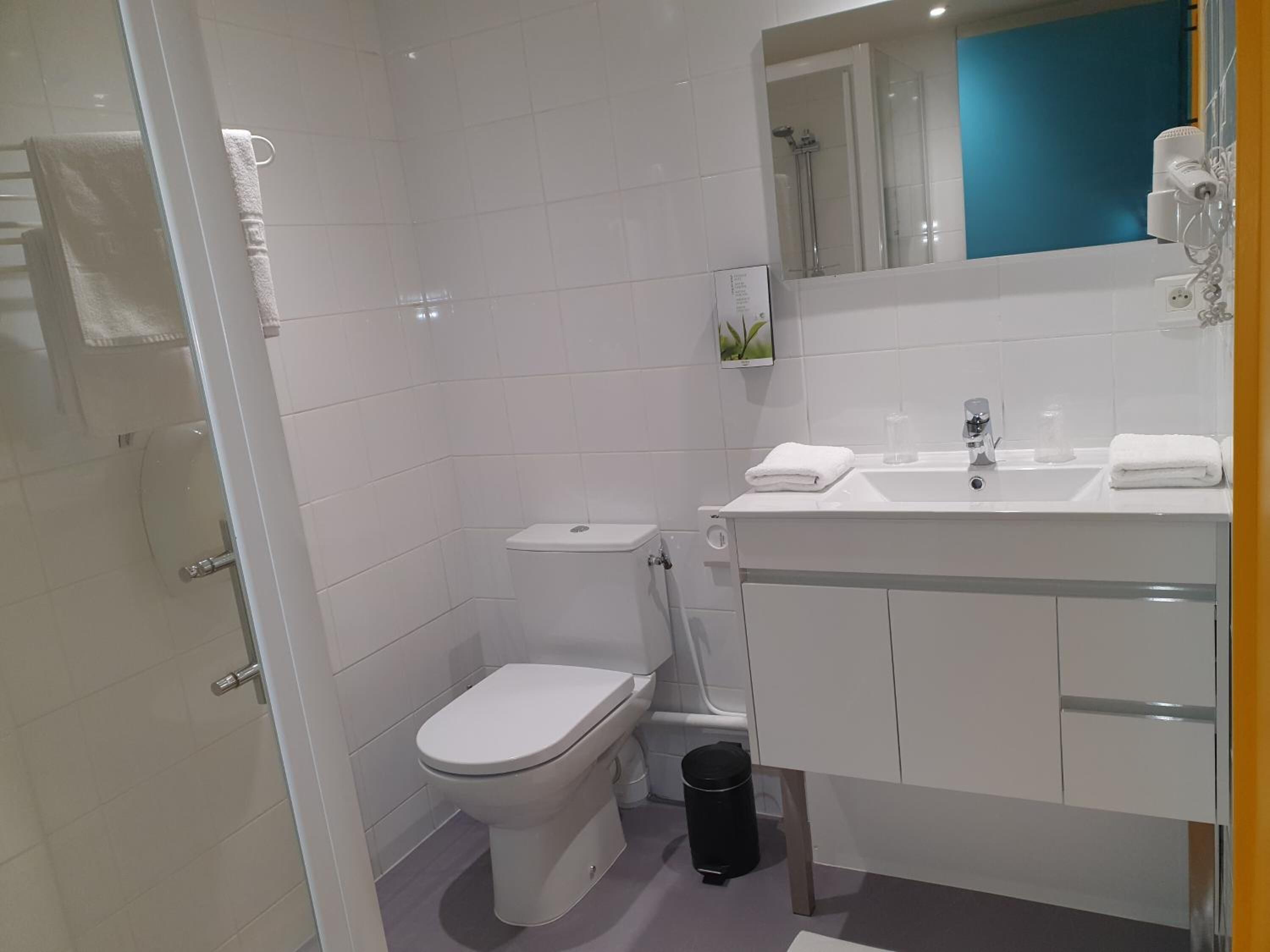 A modern bathroom with a toilet, sink, and shower.