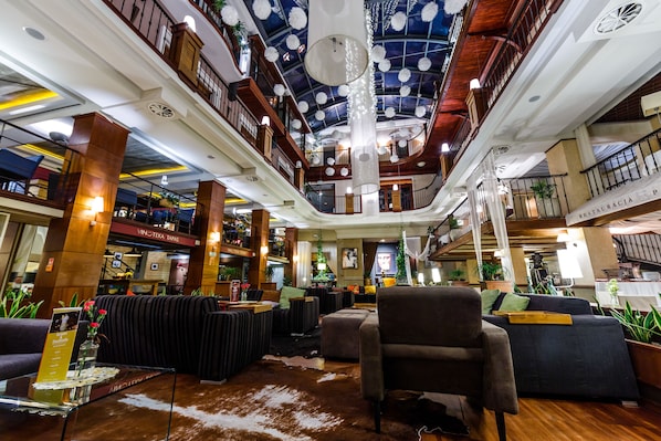 A spacious lobby with a high ceiling, multiple seating areas, and a central column.